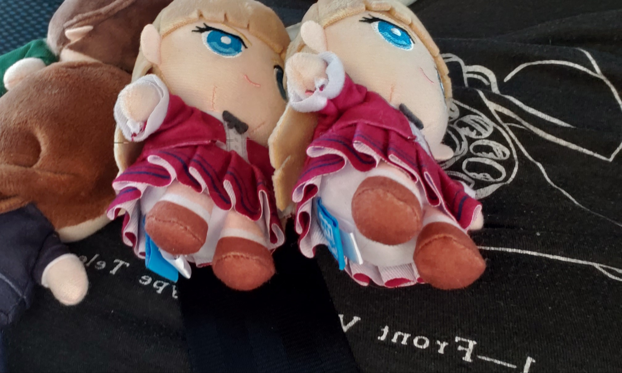 Two Gundam Wing Relena, one Duo and Heero plush laying against shirt with old fashioned house phone design.